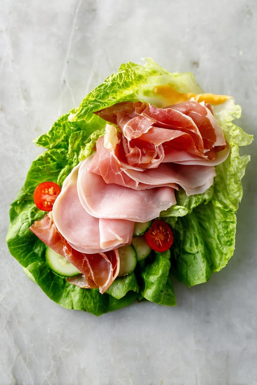 A single wrap made with three large bright green lettuce leaves forms the base layer, looking fresh and crisp with slight ruffles at the edges. On top of the lettuce, there is a thin layer of pale yellow mustard, visible in small streaks. Next, a layer of thin cucumber slices sits beneath three round slices of pale pink deli meat, topped with three slightly folded slices of deeper pink prosciutto that show a bit of shine and soft texture. Small pieces of red cherry tomatoes peek out near the edges, adding color contrast. The entire wrap rests on a white marbled surface, emphasizing the fresh and natural look of the ingredients. Photo taken with an iphone --ar 2:3 --v 7 - Low-Carb Lettuce Wrap Sandwich, healthy lettuce wrap ideas, low-carb lunch recipes, keto-friendly sandwich alternatives, quick lettuce wraps