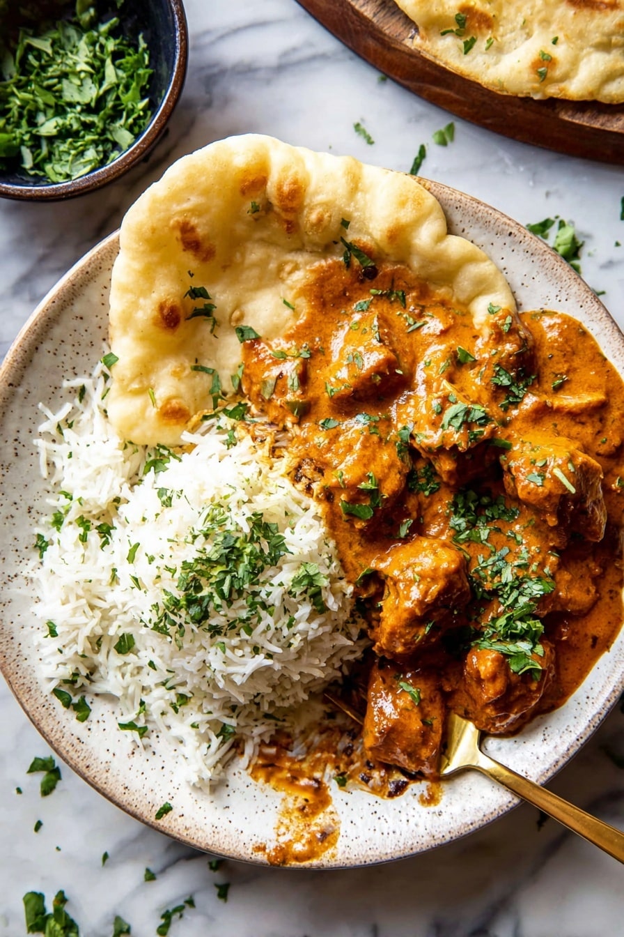 The image shows a white speckled plate with three main layers: on the left side a mound of white rice with some green herbs sprinkled on top, on the right side a thick orange-brown curry with chunks of meat covered in sauce and garnished with chopped green herbs, and around the curry and rice, a large light beige puffed and textured flatbread folded to hold the food. A gold spoon is partially placed under the rice with some sauce on it, and bits of herbs are scattered around the plate on a white marbled surface. In the top left corner, a small dark bowl filled with chopped green herbs is partially visible. Photo taken with an iphone --ar 2:3 --v 7 - Creamy Butternut Squash Butter Chicken, butternut squash chicken dinner, spicy coconut chicken, comfort food recipes, easy healthy chicken dinner