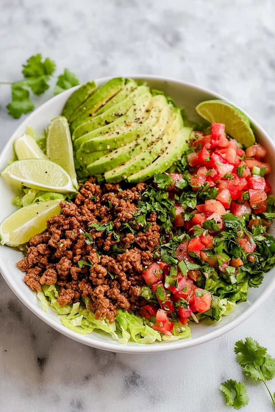 A white bowl holds four main layers arranged side by side on a white marbled surface. The bottom layer is shredded light green lettuce covering the whole bowl base. On the left, there are thin slices of ripe avocado with black pepper sprinkled on them, topped with a few cilantro leaves. Next to it are three lime wedges with a pale green color. The center layer shows cooked ground meat with small red bits, garnished with chopped cilantro. On the right side, there is a colorful mix of diced red tomatoes, green peppers, and finely chopped herbs. Some cilantro leaves are scattered over the whole dish. Photo taken with an iphone --ar 2:3 --v 7 - Taco Salad with Spiced Ground Beef, Fresh Salsa, and Avocado, easy taco salad, healthy taco salad recipe, quick dinner salads, flavorful beef taco salad, Mexican-inspired salads