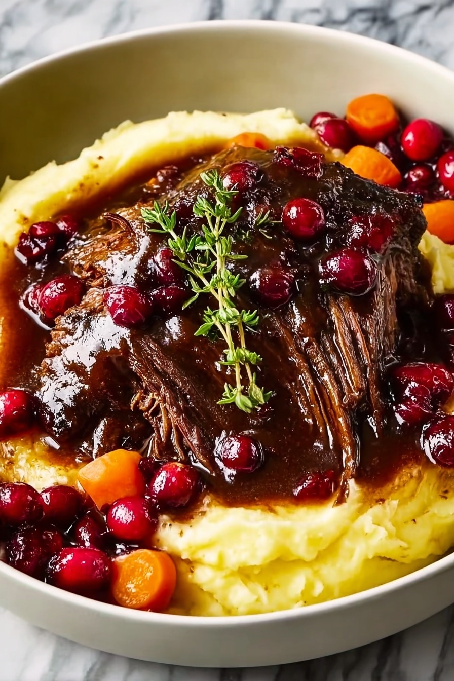 A white bowl holds a comforting layered dish starting with a base of creamy, soft mashed potatoes that have a pale yellow color and smooth texture. On top sits a large piece of tender, dark brown braised meat with visible fibers showing its softness. The meat is covered with a thick, shiny dark brown gravy that pools slightly around the edges. Bright red, glossy cranberries and slices of orange carrots surround the meat and mashed potatoes, adding color contrast. A small green sprig of fresh thyme rests on top of the meat, giving a fresh touch. The background is a white marbled texture. photo taken with an iphone --ar 2:3 --v 7 - Slow-Braised Beef Roast with Cranberry Balsamic Glaze, beef roast with cranberry balsamic glaze, tender beef roast recipes, cranberry beef main dish, gourmet beef roast