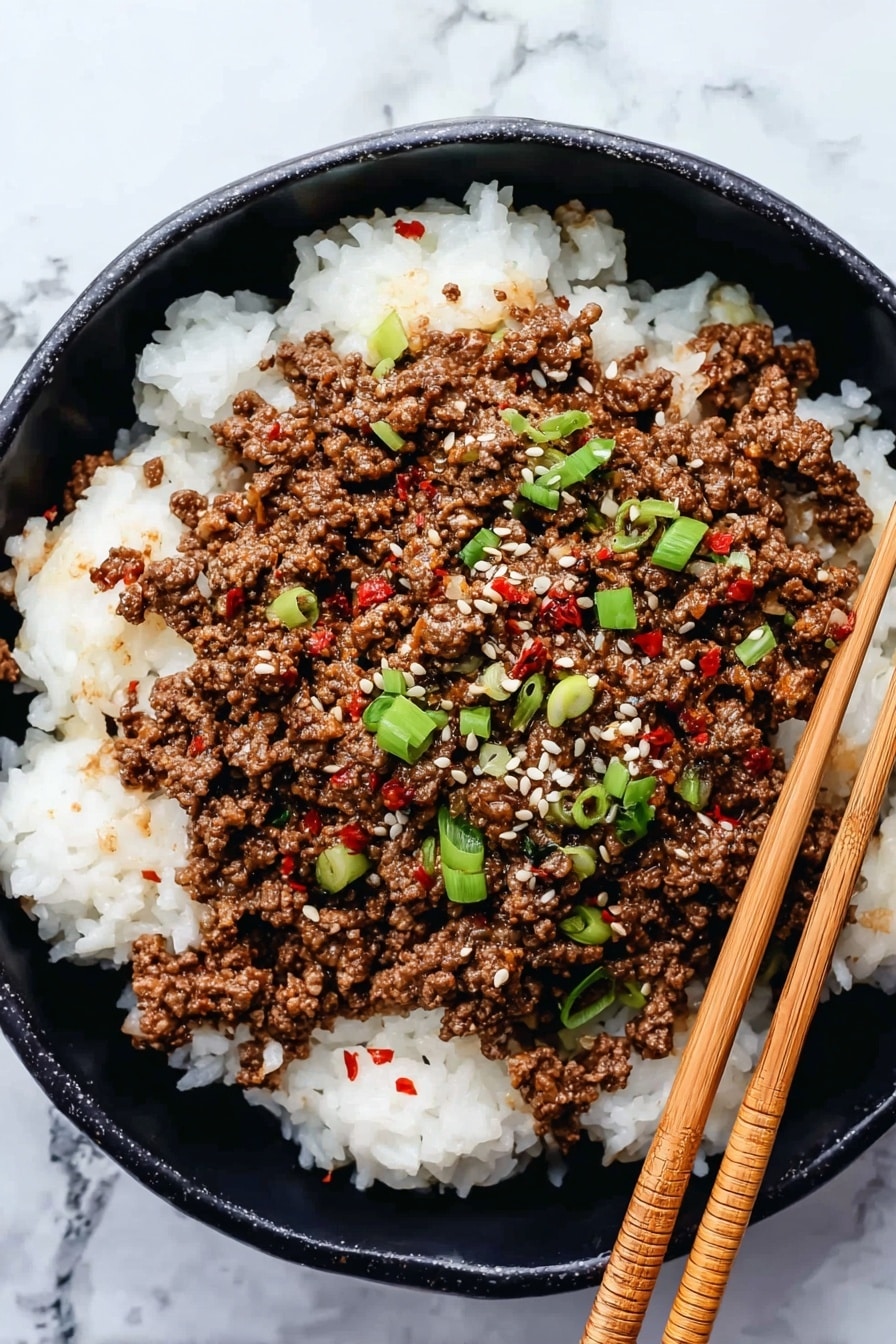 A close-up image shows cooked ground meat mixed with small chopped green onions in a black pan. The meat is brown and crumbly with pieces spread evenly across the pan. Bright green onion slices are scattered on top adding contrast. A wooden spoon is in the pan lifting a portion of the meat mix. The pan is placed on a white marbled surface. A light blue cloth is seen near the pan edge. photo taken with an iphone --ar 2:3 --v 7 - Korean Ground Beef and Rice Bowls, Korean rice bowl recipe, easy Korean beef bowls, quick weeknight dinner, flavorful beef rice bowls