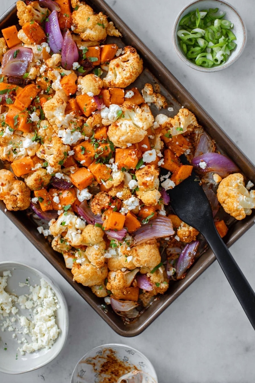 A baking tray filled with a mix of roasted cauliflower florets, orange sweet potato cubes, and sliced red onions, all lightly seasoned and scattered with small bits of white cheese and green chopped herbs. The vegetables have a slightly crispy look with a mix of bright orange, creamy white, and deep purple colors, creating a warm, freshly cooked appearance. Nearby, there is a small white bowl with chopped green onions and another white dish holding more crumbled white cheese, all placed on a white marbled surface. A black spatula rests inside the baking tray, ready to serve photo taken with an iphone --ar 2:3 --v 7 - Sheet Pan Buffalo Chicken and Sweet Potato Bowls, healthy buffalo chicken dinner, easy sheet pan chicken recipe, roasted sweet potato bowls, spicy chicken and veggie bowls