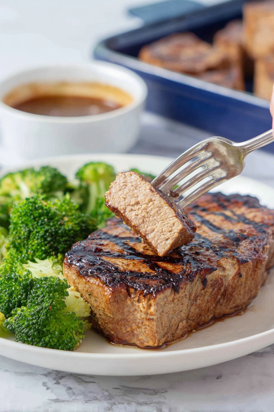 Texas Roadhouse Pork Chops Recipe 5 A white plate holds a thick grilled steak with clear dark grill lines on top and a light brown crusted texture. To the left of the steak are vibrant green broccoli florets that look fresh and steamed. In the background, a woman's hand holding a fork lifts a small piece of the steak, showing a light pink inside with a browned outer edge. Behind the plate, there is a white bowl with brown sauce and a blue container with more steak pieces on a white marbled surface. photo taken with an iphone --ar 2:3 --v 7 - Texas Roadhouse Pork Chops, pork chop marinade, juicy pork chops, grilled pork chops, easy pork chop recipes